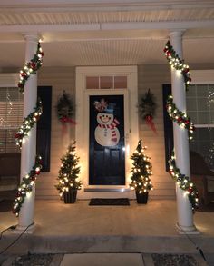 the front porch is decorated for christmas with lights and garlands on the columns, snowman