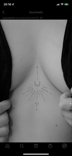 the back of a woman's breast with an arrow tattoo on it