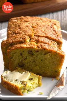 a loaf of zucchini bread on a white plate next to a knife and fork