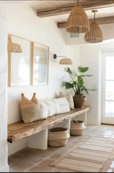 a room with some plants and baskets on the wall next to a wooden bench in front of a door