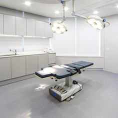 an empty hospital room with medical equipment on the floor and lights hanging from the ceiling