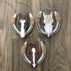 three horse head ornaments are hanging on the wall