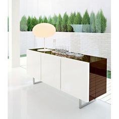 a modern kitchen with white cabinets and green trees