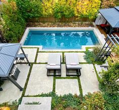 an aerial view of a backyard with a swimming pool and lounge chairs in the foreground