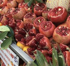 pomegranates and oranges are on display at a market for sale