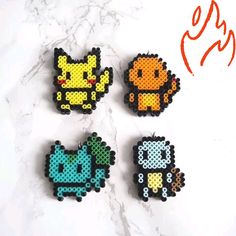 four pixelated pokemon pins sitting on top of a marble counter