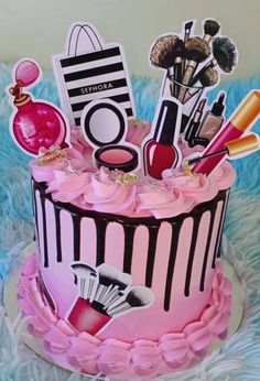 a pink and black birthday cake with lots of decorations on it's tiers