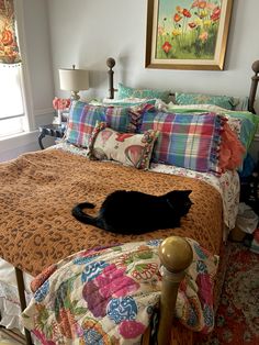 a black cat laying on top of a bed