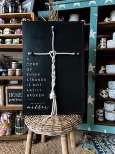 a wooden cross on top of a chair in a room with shelves and other items