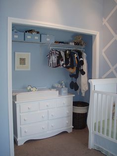 a baby's room with blue walls and white furniture