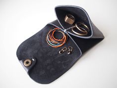 a black purse with rings and earrings on it