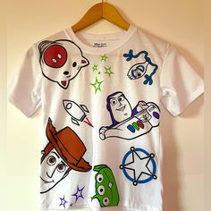 New With Tag. Disney Pixar Toy Story Kids Shirt Size:7 Color: White Made In Peru Machine Cold Wash. Material: 65% Polister, 33% Cotton. 100% Authentic! From Smoke Free Home And Pet Free Environment. Themed Short Sleeve Tops For Playtime, Themed Multicolor Tops With Cartoon Print, Themed White Tops With Character Print, White Tops With Character Print For Disney Fan Events, Themed White T-shirt For Disney Fan Events, White Cartoon Print Top For Disney Fan Events, White Fun Style T-shirt For Playtime, Themed Multicolor Cartoon Print Tops, White Character Print Tops For Playtime