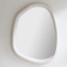 an oval shaped mirror hanging on the wall