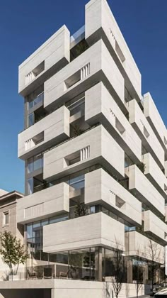 a large white building with many windows and balconies on the top floor in front of it