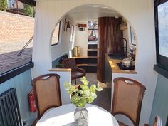 a table and chairs in a small room with an open door to the living area