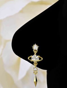 a pair of gold earrings with white stones on top and a dangling droplet in the middle