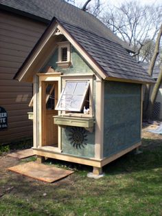 a small wooden house sitting in the grass