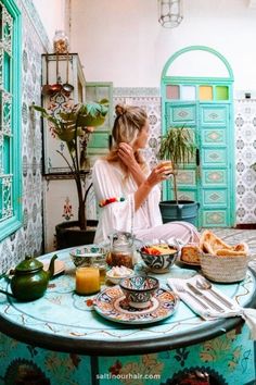 a woman sitting at a table with food on it