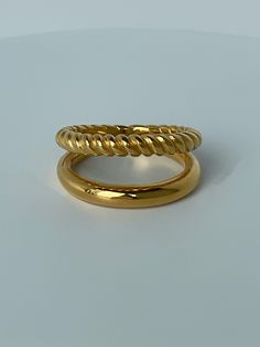 The Double Stack Ring is the perfect one-and-done piece to add to your collection. A double-ring design makes putting on your jewelry effortless. A classic gold-plated band paired with a twisted band is the perfect duo with the rest of our collection. 18K gold plating on stainless steel Classic and twisted band design Water resistant, hypoallergenic Minimalist Twisted Gold Rings, Gold Stackable Rings With Open Band In Modern Style, Modern Twist Gold Stackable Rings With Open Band, Gold Stackable Rings With Modern Twist, Gold Stackable Rings With Open Band And Modern Twist, Gold Rings With A Modern Twist, Twisted Gold Ring For Gift, Gold Twisted Promise Ring, Twisted 14k Gold Ring