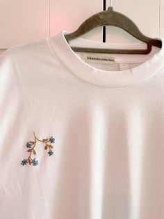 Flowers on branch embroidered t-shirt White T-shirt With Embroidered Logo For Spring, Cotton T-shirt With Embroidery For Spring, White Tops With Embroidered Logo For Spring, White T-shirt With Embroidered Text For Fall, Fall Cotton T-shirt With Floral Embroidery, Spring Short Sleeve Tops With Contrast Embroidery, Spring Tops With Contrast Embroidery And Short Sleeves, Short Sleeve Tops With Contrast Embroidery For Spring, White Floral Embroidered T-shirt For Spring