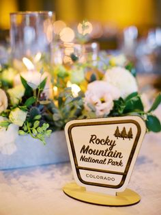 there is a table with flowers and rocks in the mountains national park logo on it