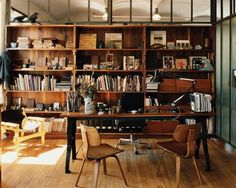 an office with lots of bookshelves and chairs in the middle of the room