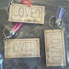 three wooden keychains with the words loved and love on them