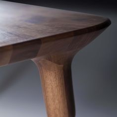 a close up of a wooden table with one leg bent down and the other end turned upside down