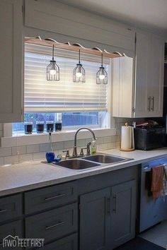 a kitchen sink under a window in front of a counter top with a coffee maker on it