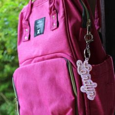 a pink backpack hanging on the side of a door