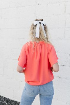 ALL SALES FINAL NOT ELIGIBLE FOR RETURN Get ready for some playful style with the Elliot Top! Made with light weight material, this top features a trendy v-neck mock ruffled neckline and adorable flutter sleeves. In a beautiful coral color, it's perfect for adding a pop of fun to any outfit. (Warning: May induce feeling of pure joy and compliments!) Fits true to size. Model is wearing a small and is 5'4". Plus model is wearing a 1X and is 5'5". Size Chart Length Bust S 27" 40" M 27" 42" L 27" 44 Trendy Flutter Sleeve Top For Summer, Trendy Summer Short Sleeve Top With Flutter Sleeves, Trendy Short Sleeve Top With Flutter Sleeve For Summer, Spring Casual Flowy V-neck Top, Flowy V-neck Summer Top, Flowy V-neck Top For Spring, Chic V-neck Short Sleeve Top For Spring, Orange Ruffled Short Sleeve Blouse, Summer Flutter Sleeve Blouse