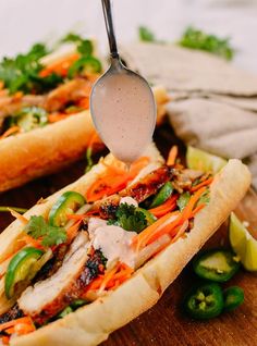 a spoon is being used to scoop into a sandwich with meat and veggies