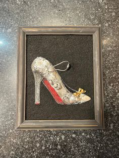 a pair of high heeled shoes is in a frame on the floor next to a wall