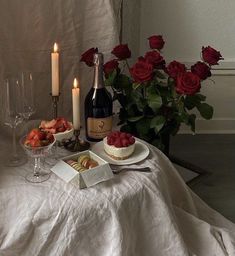 a table topped with wine, cheese and strawberries next to two glasses filled with champagne