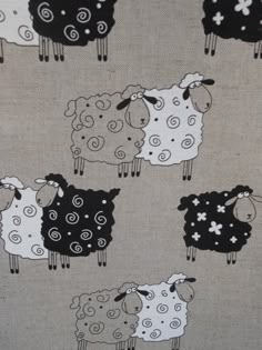 black and white sheep are standing together on a beige background