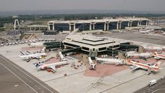 an airport with several planes parked on the tarmac and in front of it is a terminal