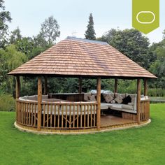 a wooden gazebo sitting on top of a lush green field