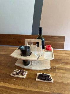 a wine bottle and some chocolates on a wooden table with two bottles of wine