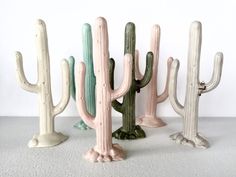 four ceramic cactus sculptures in different colors and sizes