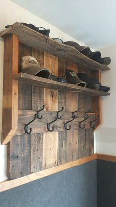 a wooden shelf with shoes on top of it and hooks hanging from the wall above