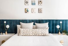 a white bed with blue headboard and pillows