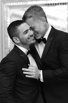 two men in tuxedos hugging each other