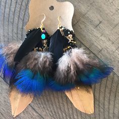 two pairs of earrings with feathers hanging from them