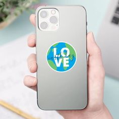 a person holding up an iphone case with the words love in blue and green on it