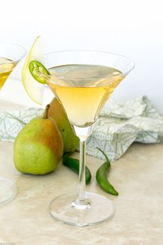 two glasses filled with white wine and pears