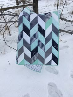 a quilt is hanging on a clothes line in the snow