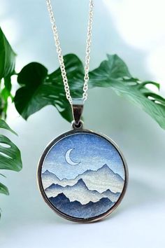 Celebrate your special milestone with our exquisite Mountain Pendant Necklace, a truly unique piece designed to capture the beauty of nature and the essence of your journey together. Perfect for a 5th anniversary gift, this handcrafted wood necklace symbolizes strength, endurance, and the peaks and valleys you've conquered as a couple. Each pendant is meticulously made from high-quality wood, showcasing the intricate details of a mountain landscape, and is paired with your choice of a gold or si Nature-inspired Etched Jewelry For Gifts, Nature-inspired Etched Jewelry Gift, Nature-inspired Necklace With Round Pendant For Anniversary, Nature-inspired Round Necklace As A Gift For Her, Nature-inspired Round Pendant Jewelry As A Gift For Her, Nature-inspired Round Pendant Necklace For Anniversary, Nature-inspired Round Necklace For Her, Nature-inspired Silver Moon Shaped Jewelry, Nature-inspired Silver Moon Jewelry