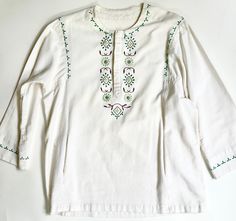 Handmade vintage 60's/70's folk style embroidered natural white cotton tunic top Velcro closure and two front pockets Seems to fit a modern XS/S depending on how you want it to drape.  Photographed on a size 2/4 dress form and it fits well.  Please use measurements to ensure proper sizing. Measurements (laying flat): Shoulder seam-to-shoulder seam: 17" Pit-to-pit: 22" Top of shoulder-to-hem: 27" Pit-to-cuff: 15-1/2" Great vintage condition with minor wear and a small pull in the weave on the bot White Embroidered Hippie Tops, White Cotton Hippie Blouse, Traditional Cream Cotton Top, White Embroidered Cotton Tunic Top, White Cotton Embroidered Tunic Top, Vintage White Embroidered Cotton Top, White Cotton Peasant Embroidered Top, Cotton Tunic Tops, Modern Wardrobe