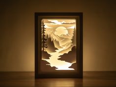 a paper cut landscape is lit up by the light coming from it's shadow