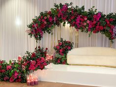 flowers and candles are on display in front of a white backdrop